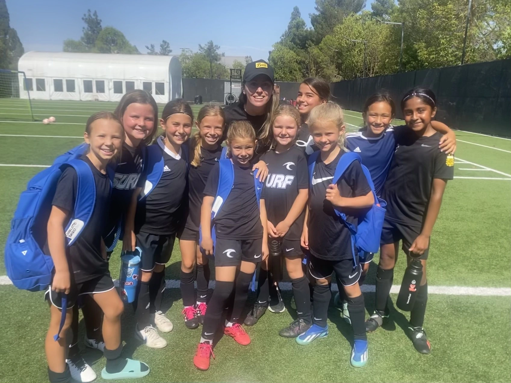 A group of 1991 youth players and a coach on a training field