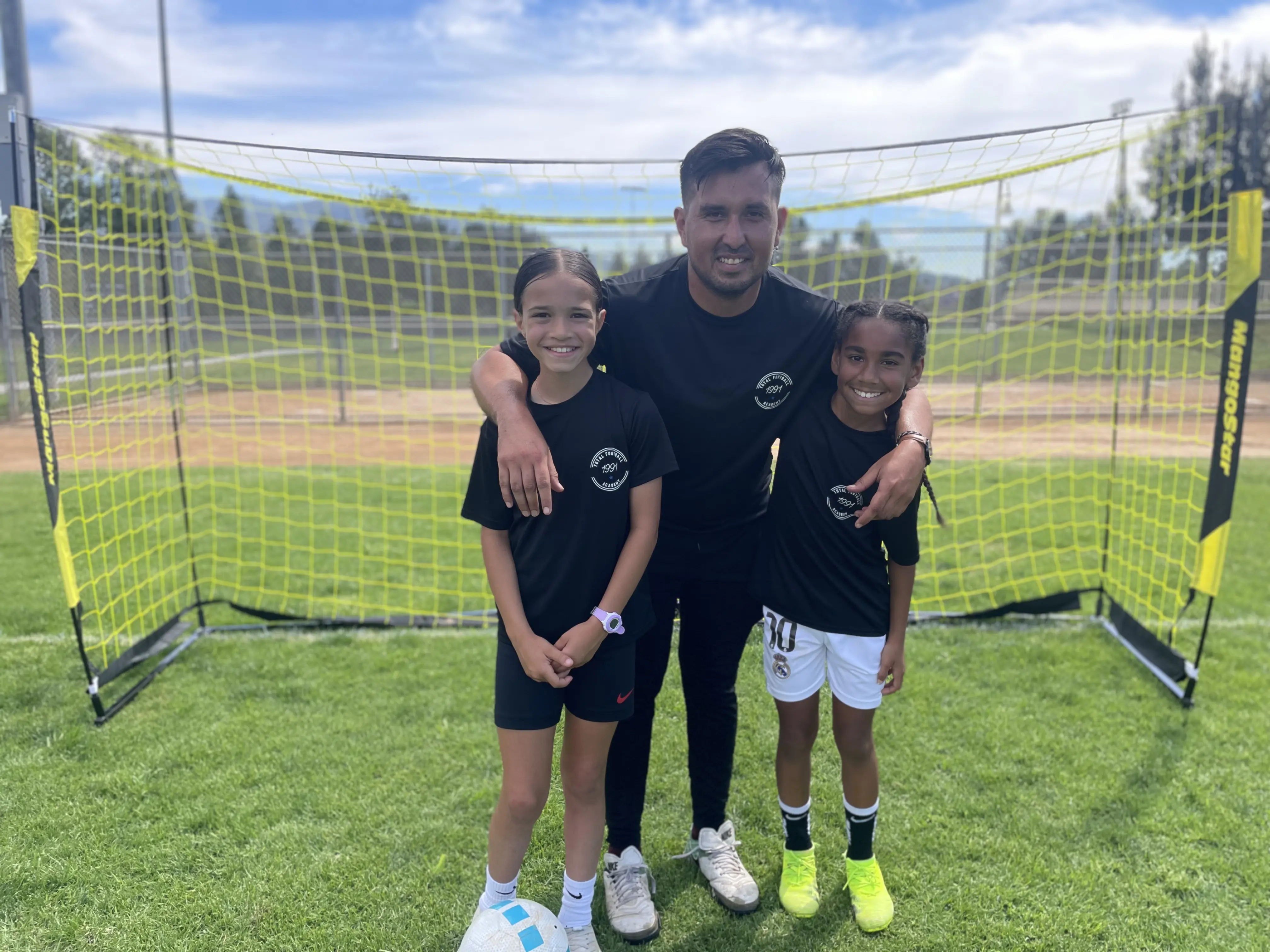 1991 coach with two young players in front of a training goal